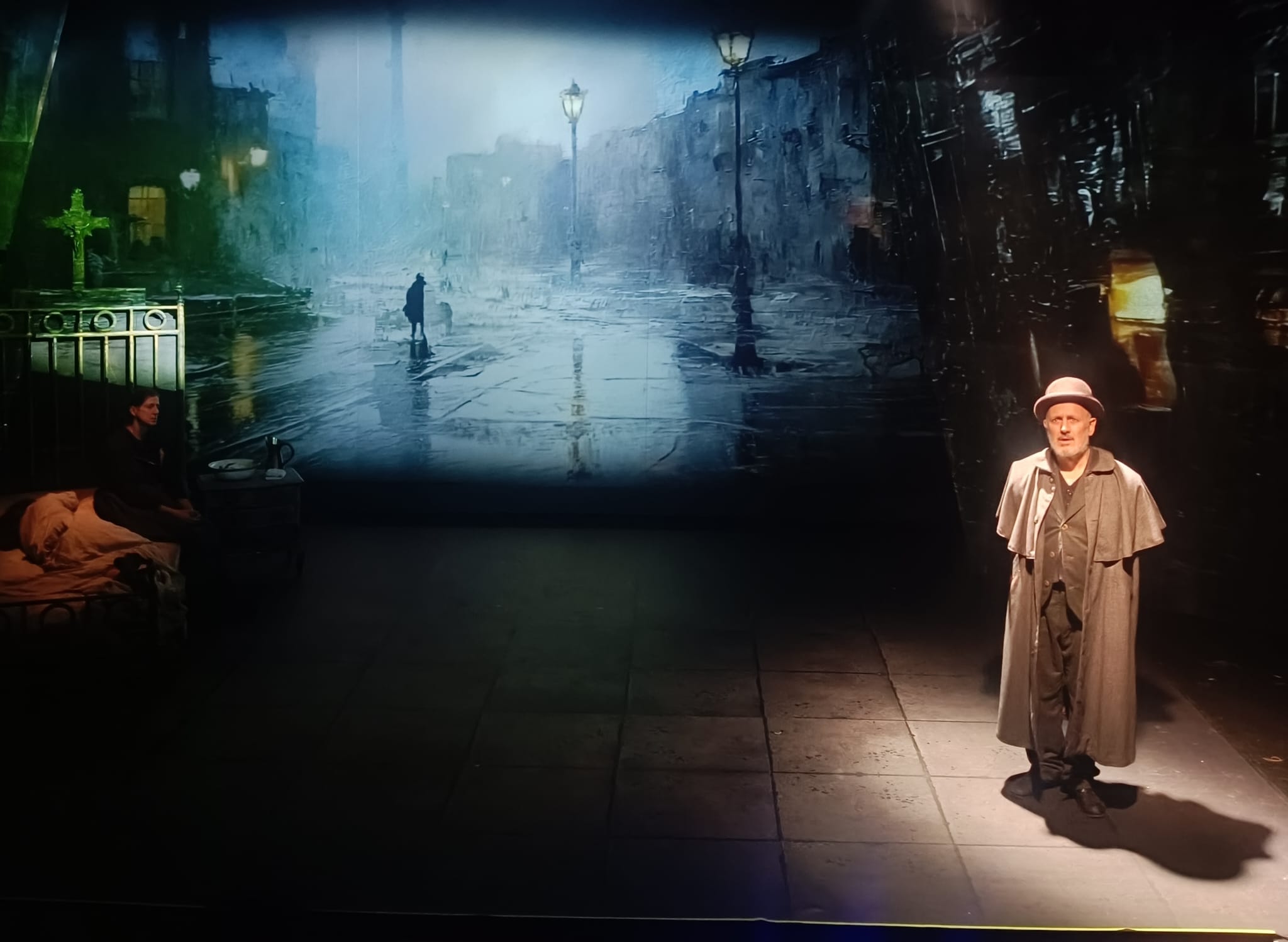 Escenografía de Noche: proyección de una calle y actores en escena